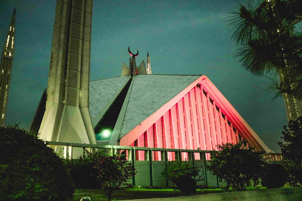 Faisal Mosque Islamabad glowing at sunset with visitors